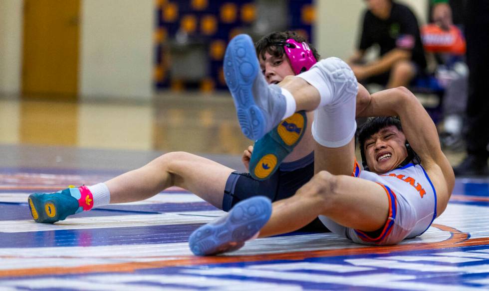 SLAM's Eric Bice, left, fights for control on the mat with Bishop Gorman's Elijah Tabasa during ...