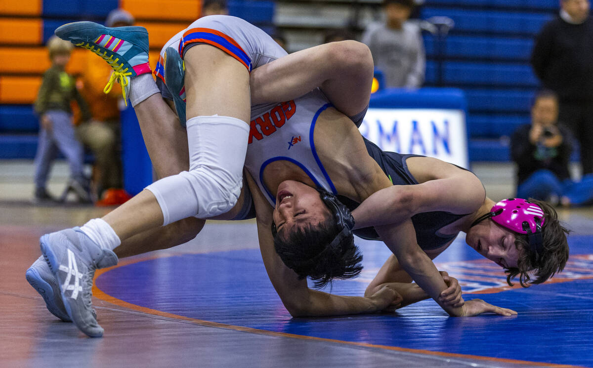 Bishop Gorman's Elijah Tabasa, left, is wrapped up by SLAM's Eric Bice on the mat during their ...