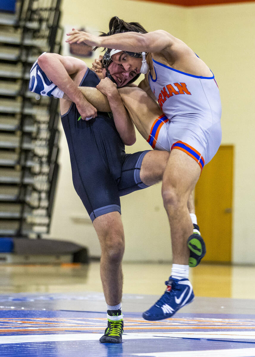 SLAM's Isaac Balden, left, sweeps out the leg of Bishop Gorman's Chance Leon-Guerrero during th ...