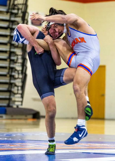 SLAM's Isaac Balden, left, sweeps out the leg of Bishop Gorman's Chance Leon-Guerrero during th ...