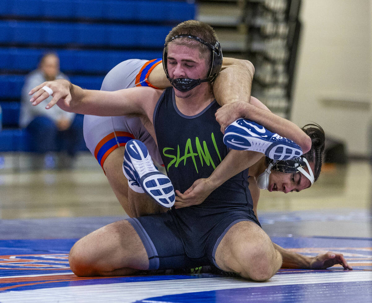 SLAM's Isaac Balden, left, has Bishop Gorman's Chance Leon-Guerrero over his back during their ...