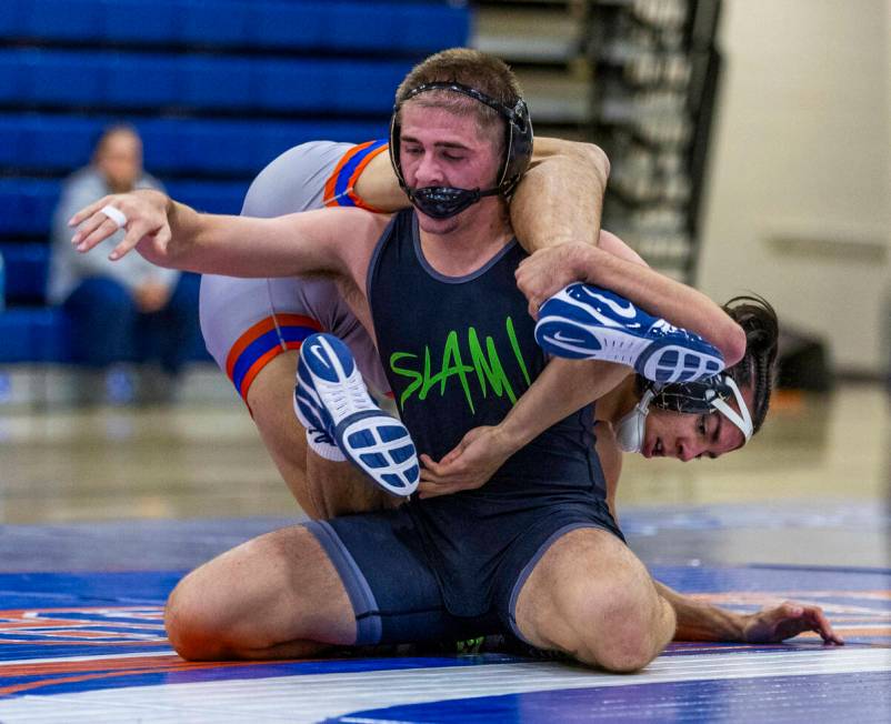 SLAM's Isaac Balden, left, has Bishop Gorman's Chance Leon-Guerrero over his back during their ...