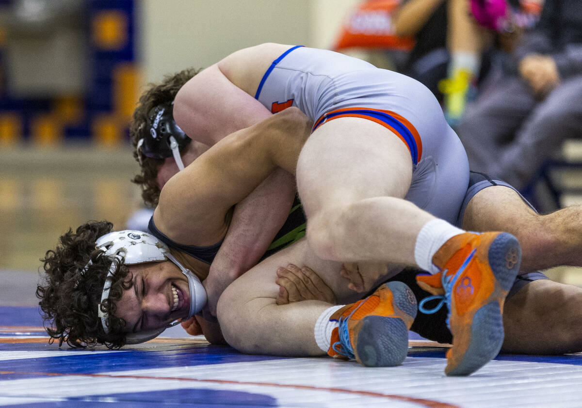 Bishop Gorman's Harrison Smith, top, drives SLAM's Gabe Delgado down onto the mat during their ...