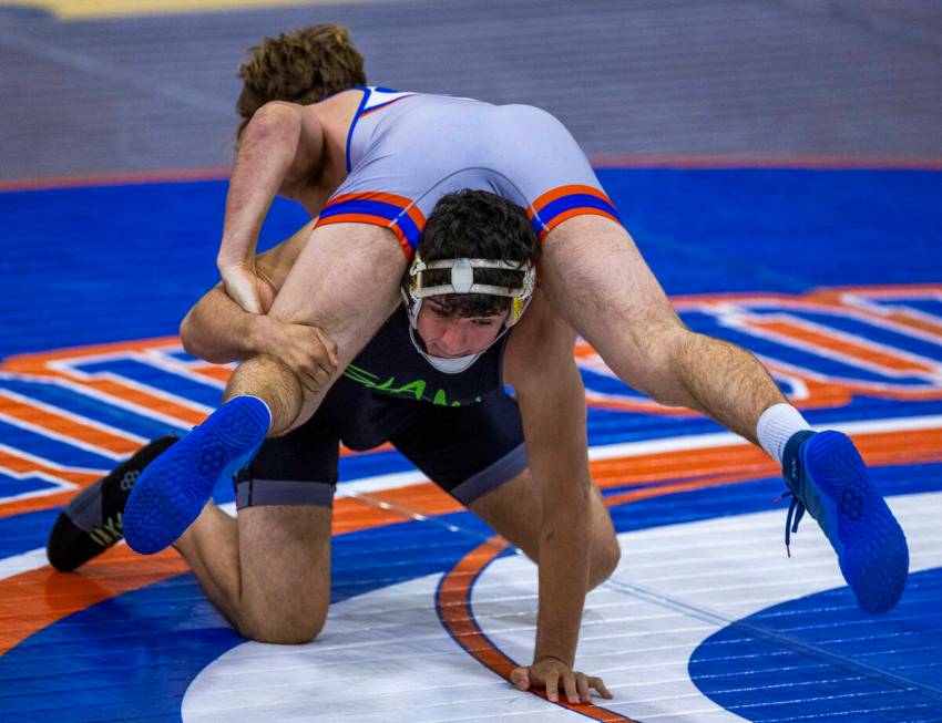 SLAM's Santiago Cabrera, front, gets underneath of Bishop Gorman's William Mueller during their ...