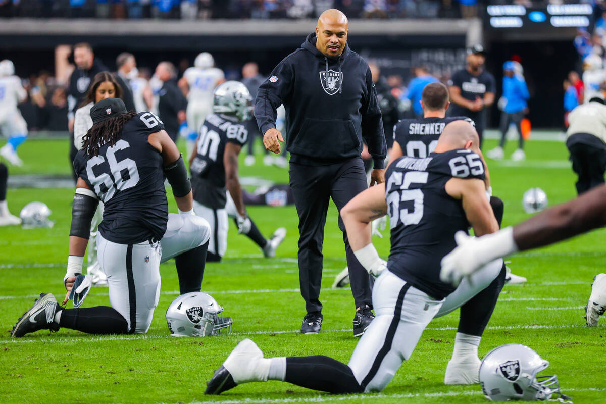 Raiders head coach Antonio Pierce greets his players during warmups before an NFL football game ...