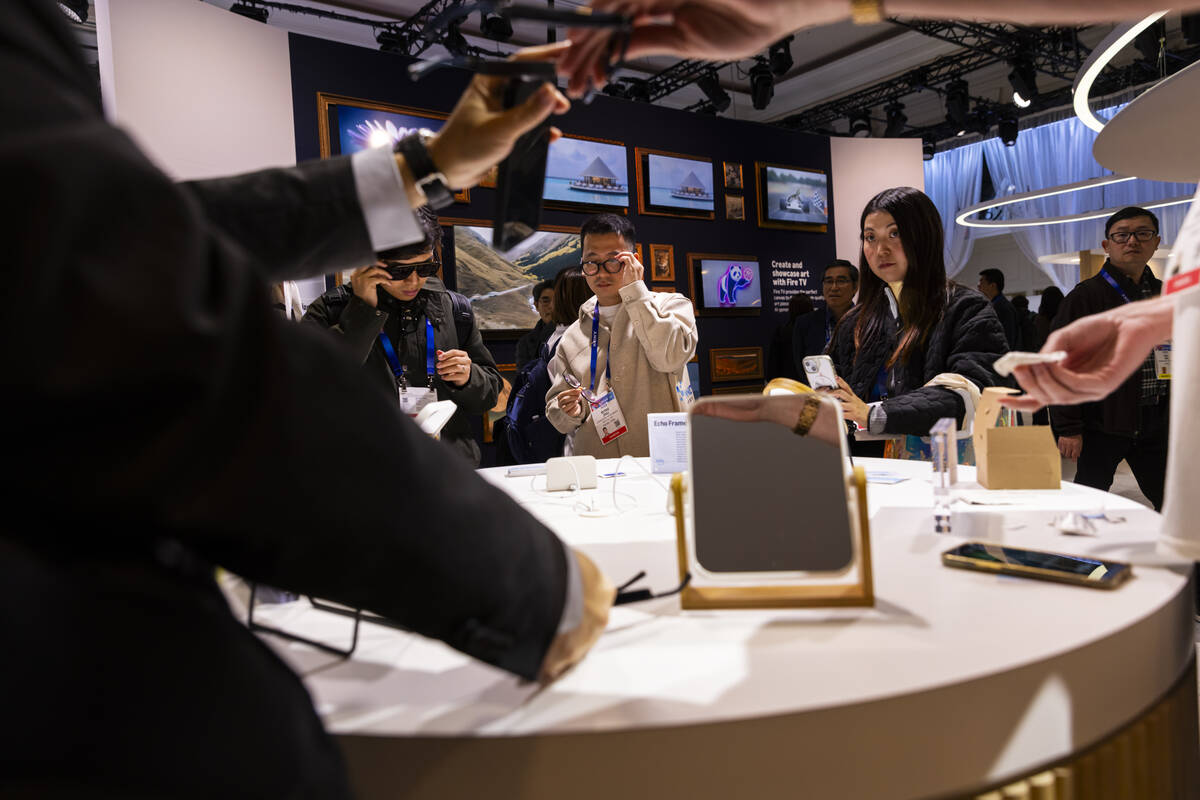 Attendees check out the Amazon Echo Frames glasses during CES at The Venetian Expo on Tuesday, ...