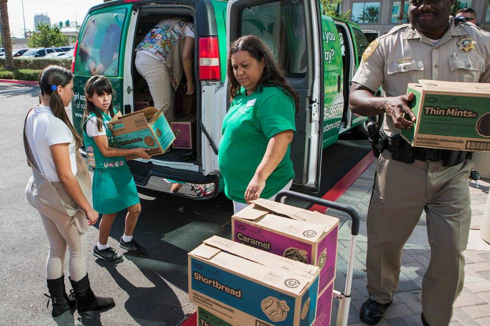 Mary, 10, second from left, carries a box of Girl Scout cookies in front of Las Vegas Metropoli ...