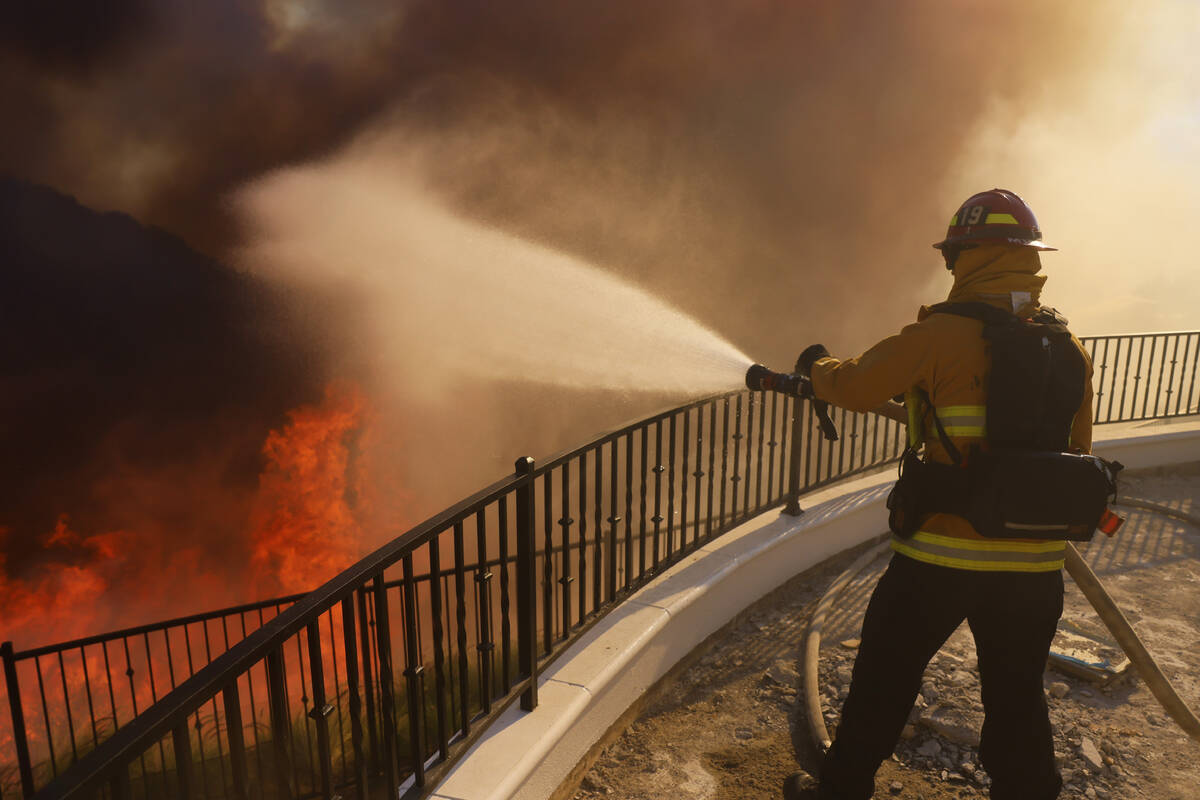 A firefighter makes a stand in front of the advancing Palisades Fire in the Pacific Palisades n ...