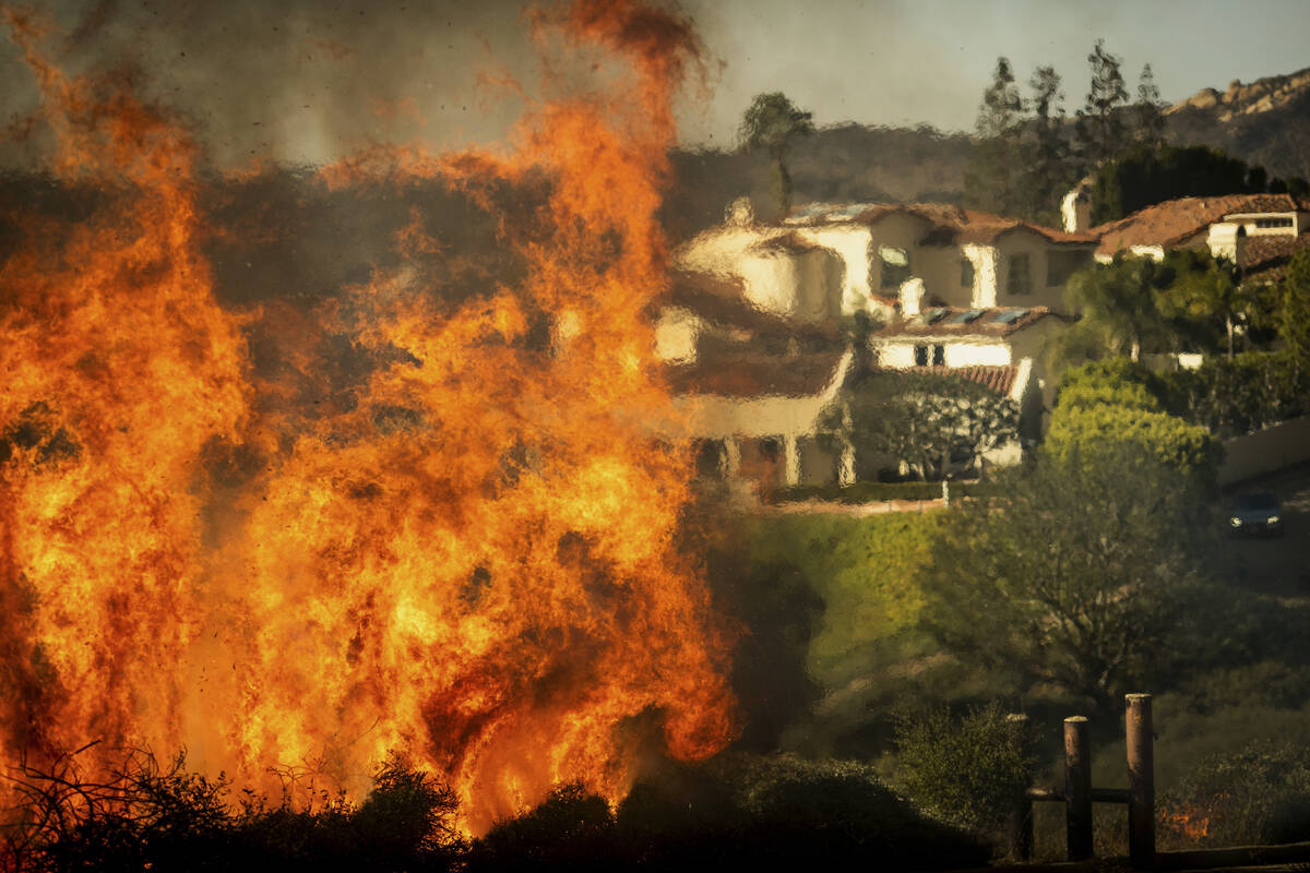 Flames rise as the Palisades Fire advances on homes in the Pacific Palisades neighborhood of Lo ...