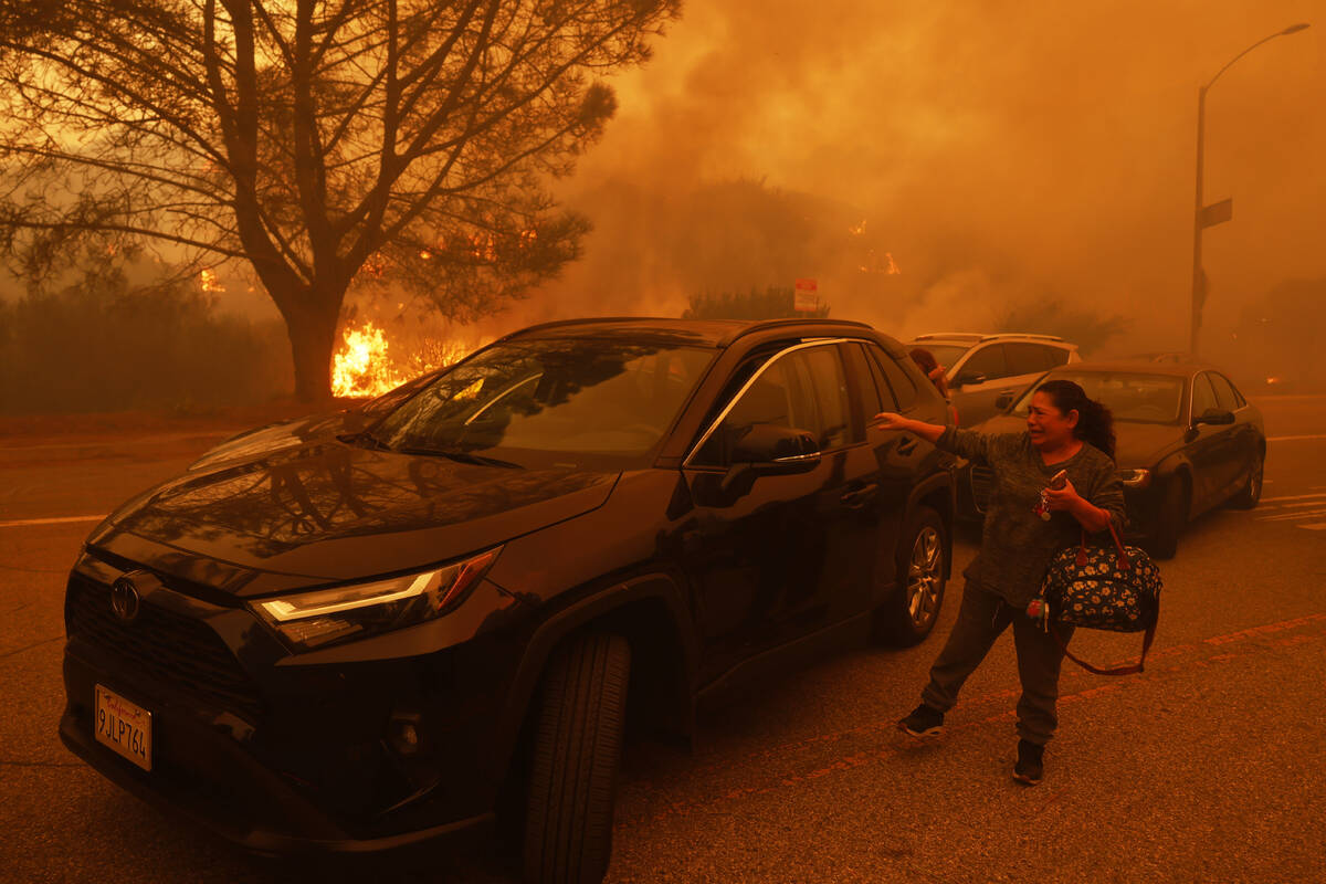 A woman cries as the Palisades Fire advances in the Pacific Palisades neighborhood of Los Angel ...