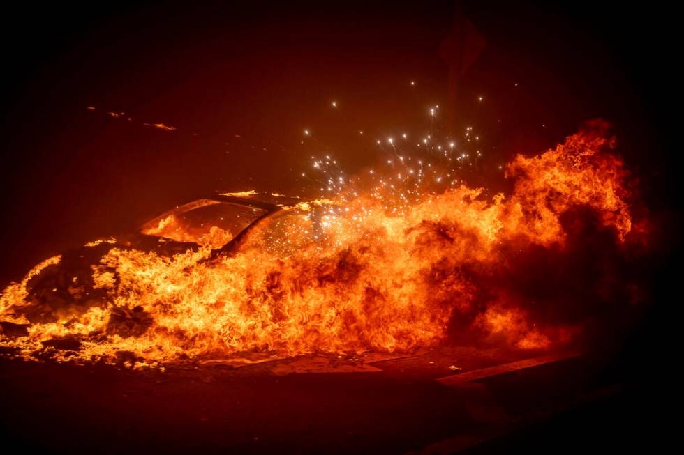 A vehicle burns as the Palisades Fire advances in the Pacific Palisades neighborhood of Los Ang ...