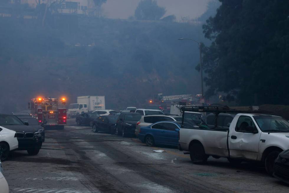 Vehicles are left stranded off the side of the road after residents tried to flee from the Pali ...