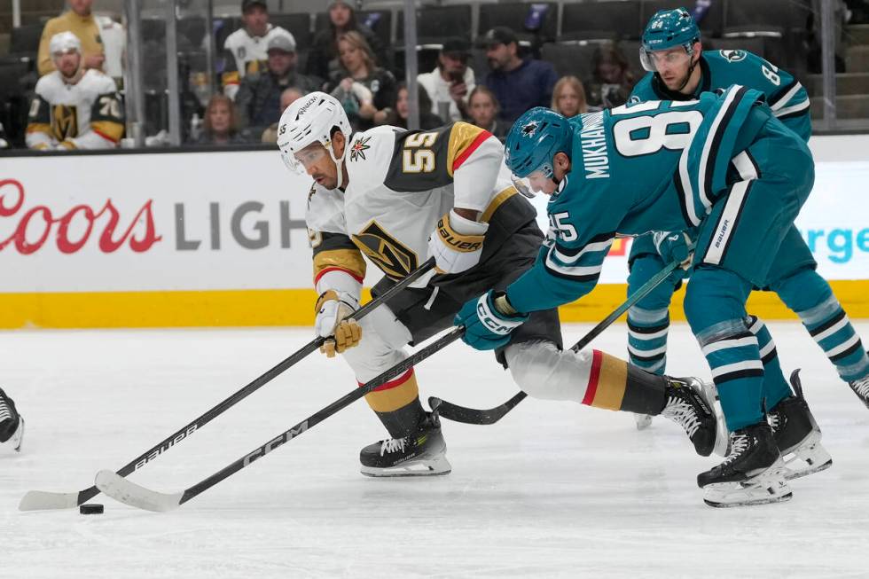 Vegas Golden Knights right wing Keegan Kolesar (55) reaches for the puck next to San Jose Shark ...