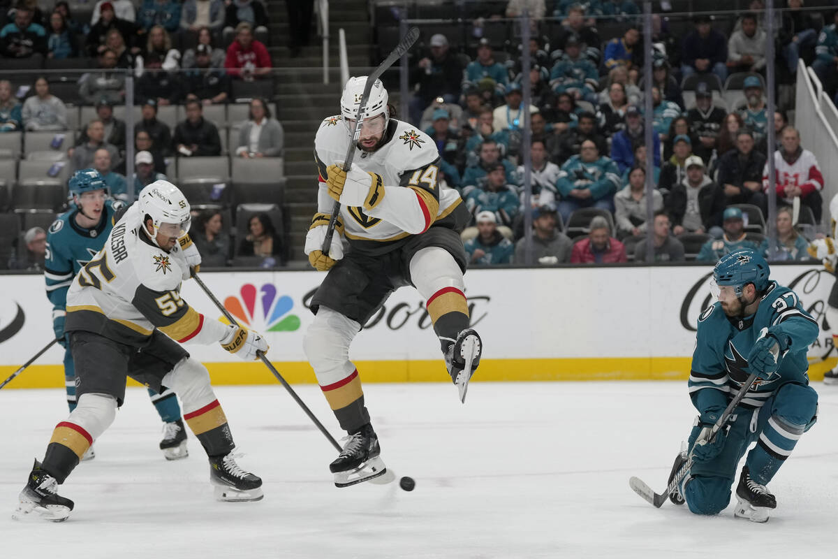 Vegas Golden Knights defenseman Nicolas Hague, middle, jumps over a shot by right wing Keegan K ...