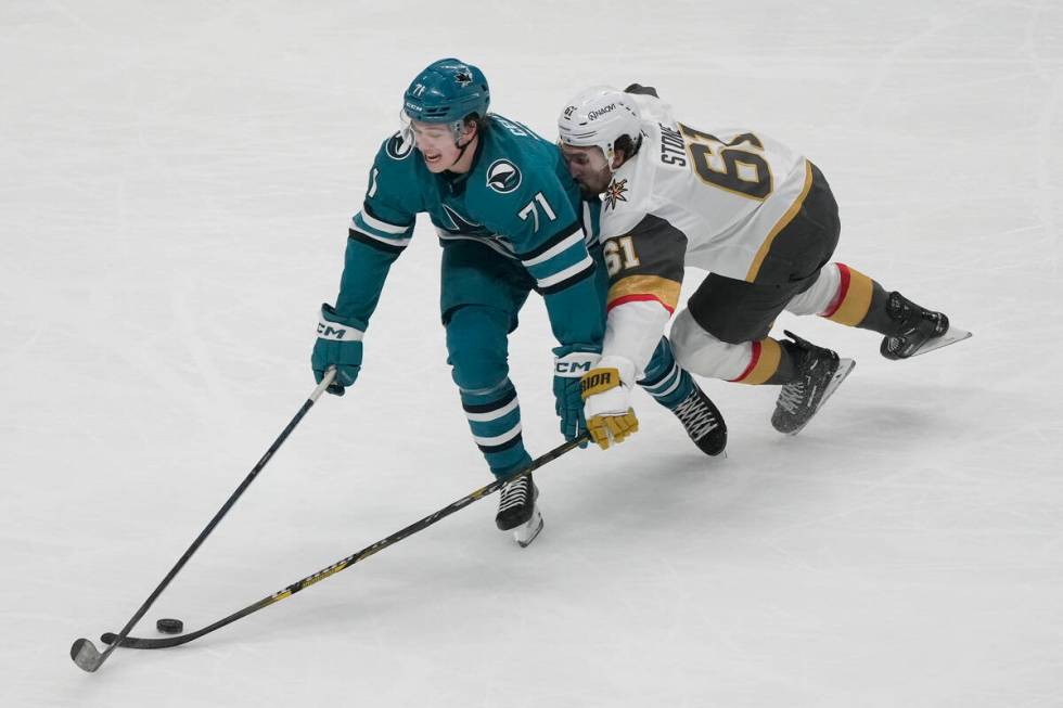 Vegas Golden Knights right wing Mark Stone (61) reaches for the puck from behind San Jose Shark ...