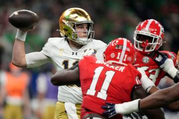 Notre Dame quarterback Riley Leonard, left, passes as he is pressured by Georgia linebacker Jal ...