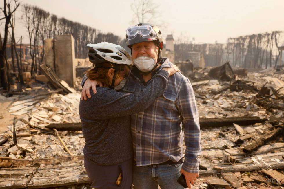 Claudio and Kathleen Boltiansky embrace in their fire-ravaged neighborhood after the Palisades ...