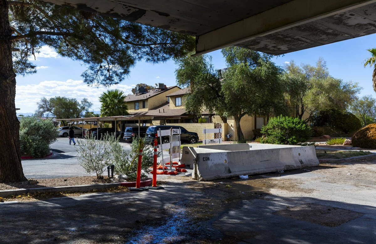 FILE - A resident surrounds a barricaded area where seeping water caused a sinkhole in one of t ...