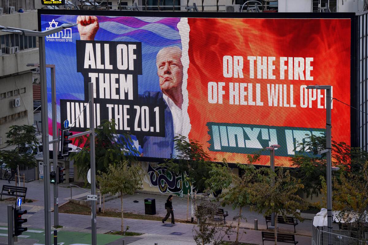 An electronic billboard beams an image of President-elect Donald Trump and references his threa ...