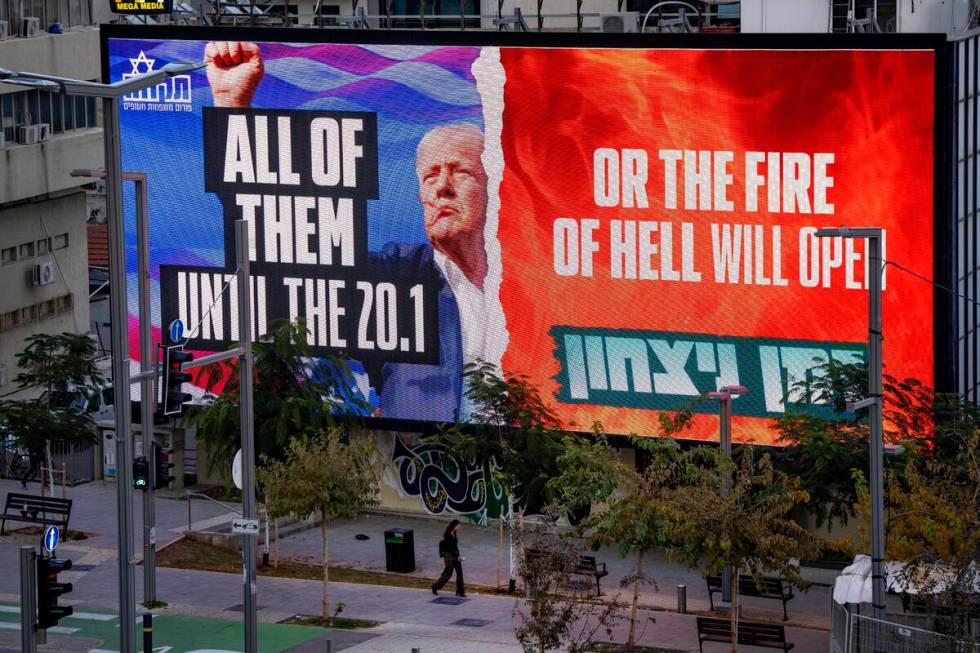 An electronic billboard beams an image of President-elect Donald Trump and references his threa ...