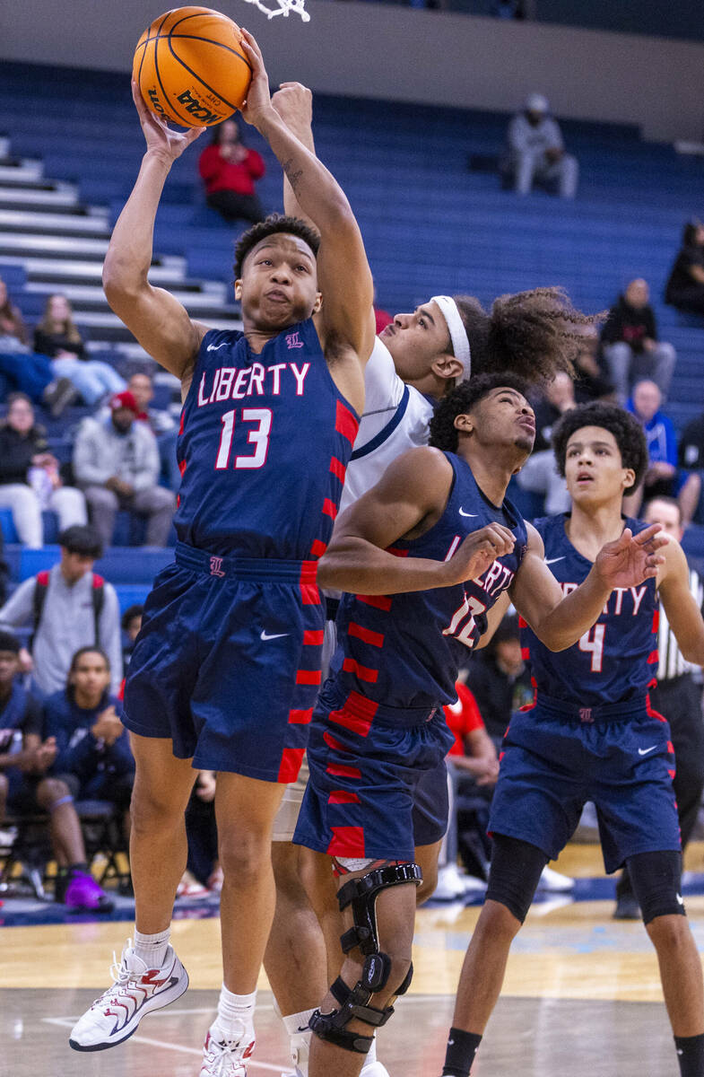 Liberty's Jaden Riley (13) posts up for a shot over Centennial's Jayonni Durrough (25) during t ...