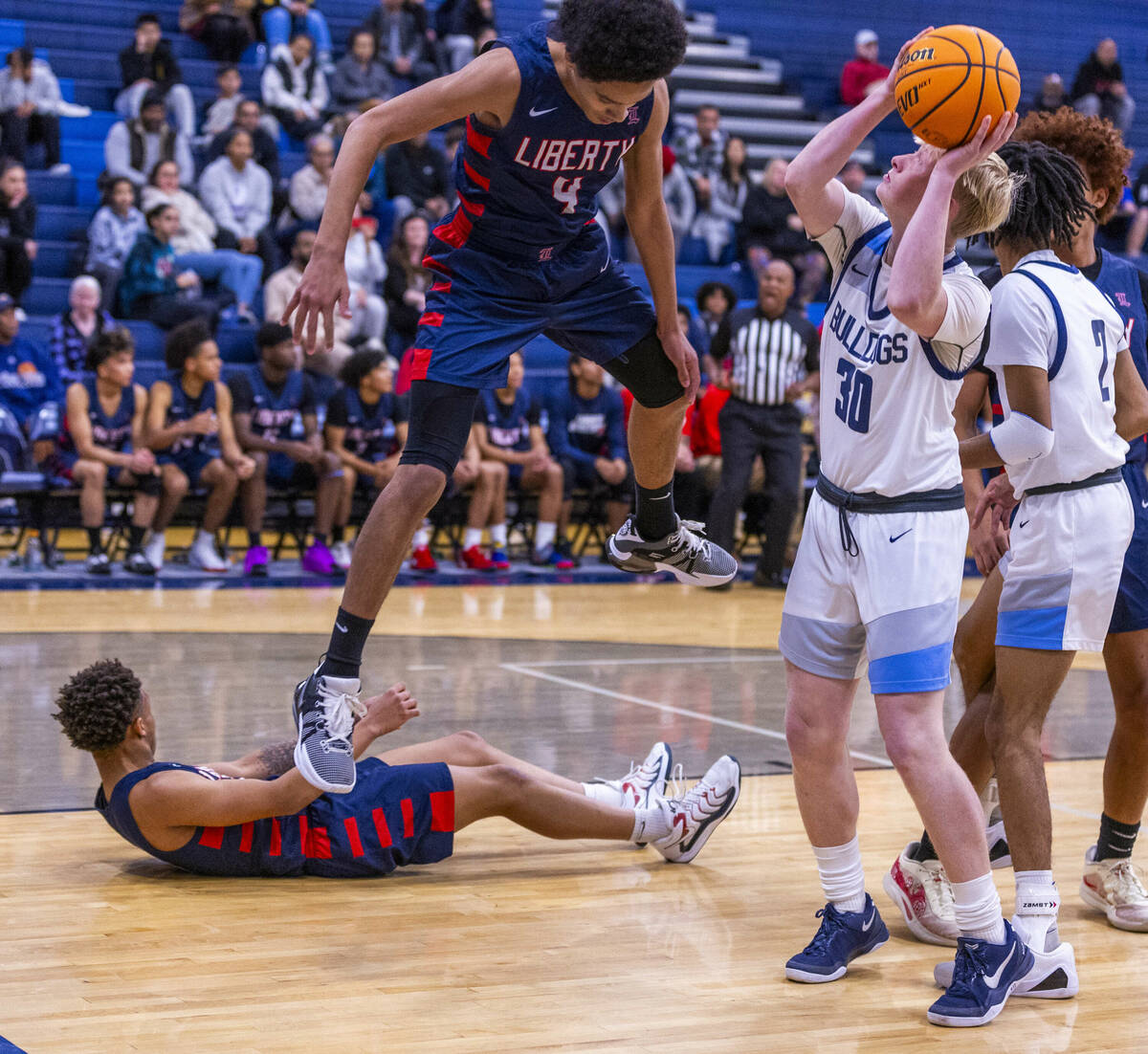 Centennial's Cooper Jenkins (30) secures a rebound against Liberty's Jaden Riley (13) and Taytu ...