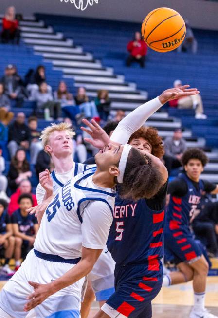 Centennial's Jayonni Durrough (25) and Liberty's Dante Steward (5) battles for a rebound during ...