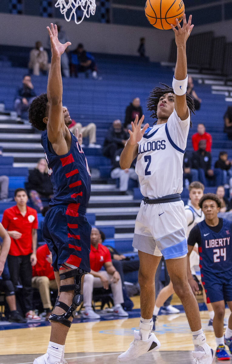 Liberty's Evan Hilliard (12) defends as Centennial's Zyon Harris (2) gets off a shot during the ...