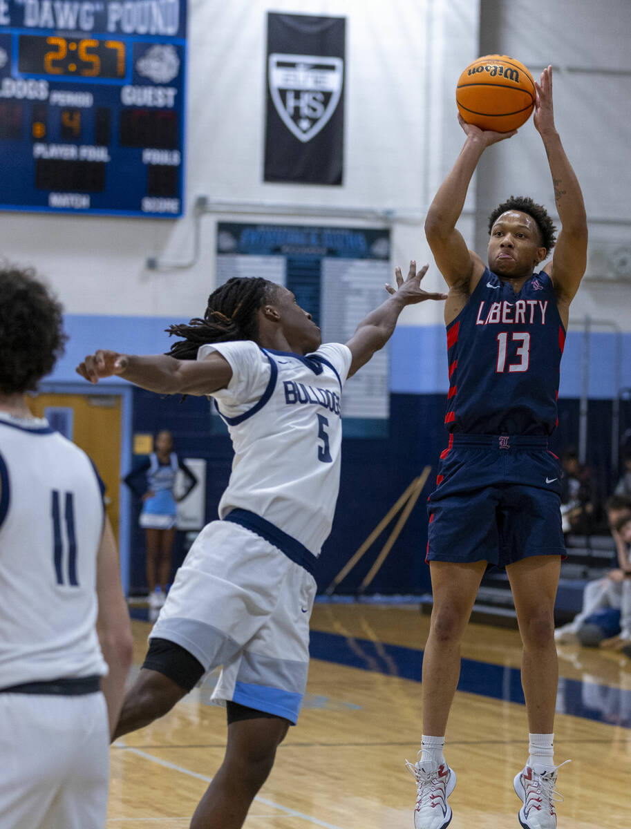 Liberty's Jaden Riley (13) posts up for a shot over Centennial's Jayden Ceaser (5) during the s ...