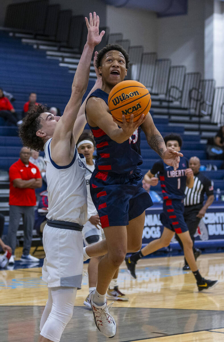 Liberty's Jaden Riley (13) gets inside of Centennial's Jaxon Price (11) for a basket during the ...