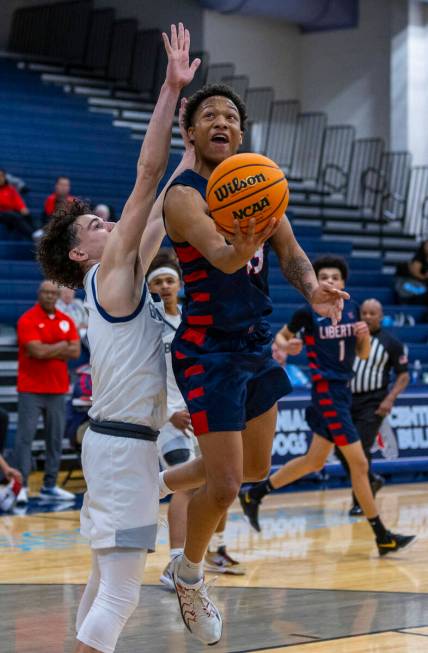 Liberty's Jaden Riley (13) gets inside of Centennial's Jaxon Price (11) for a basket during the ...