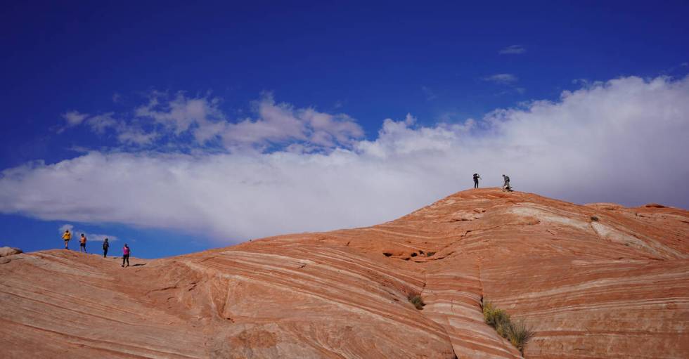 Visitors walk along the Fire Wave trail, a moderately challenging 1.5 mile round-trip hike with ...