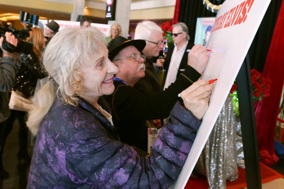 Stephanie Myers signs a giant card during a kick off to celebrate what would have been Elvis Pr ...