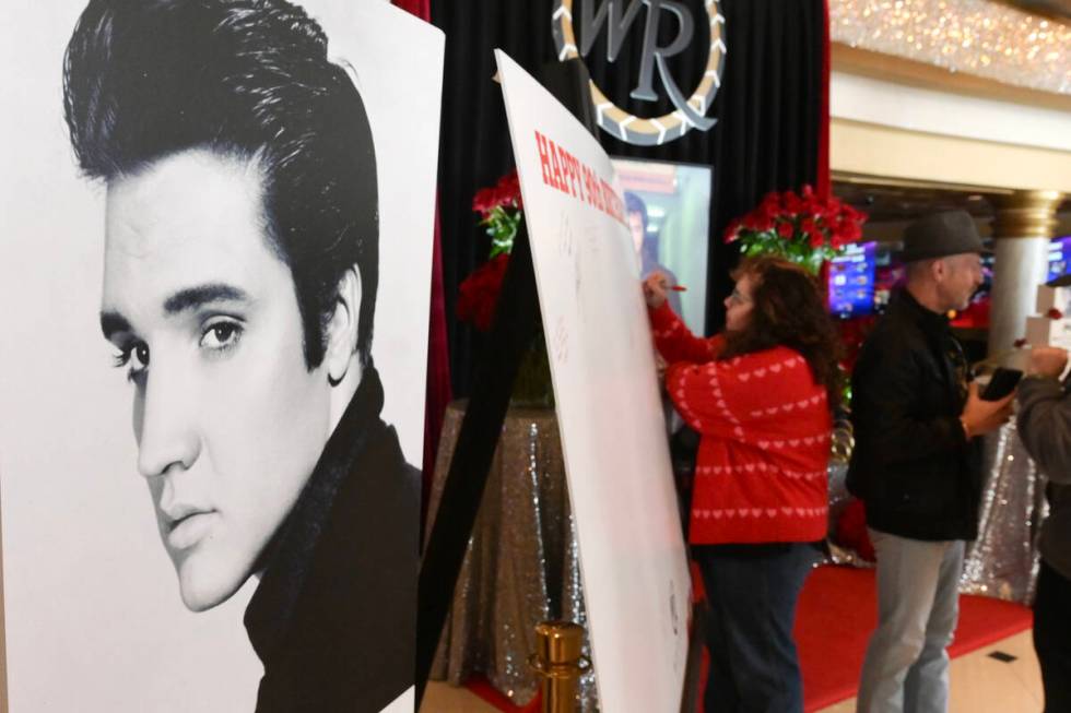 Guests sign a giant card next to a photo of Elvis Presley during a kick off to celebrate what w ...