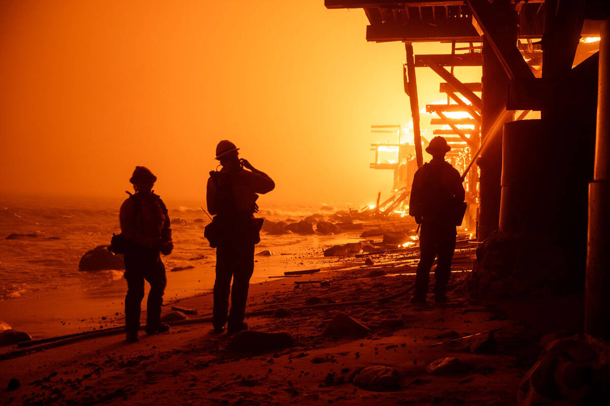 Firefighters battle fire from the surf as beachfront homes go up in flames along Pacific Coast ...