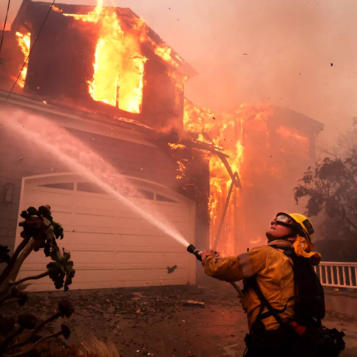 Firefighters battle a house fire off Bollinger Drive in Pacific Palisades on Tuesday, Jan. 7, 2 ...