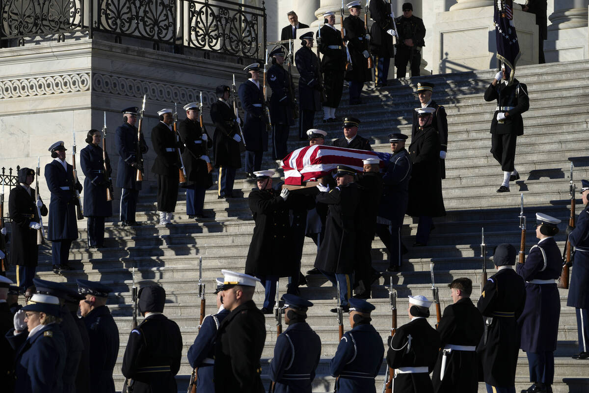 A joint services body bearer team carries the flag-draped casket of former President Jimmy Cart ...