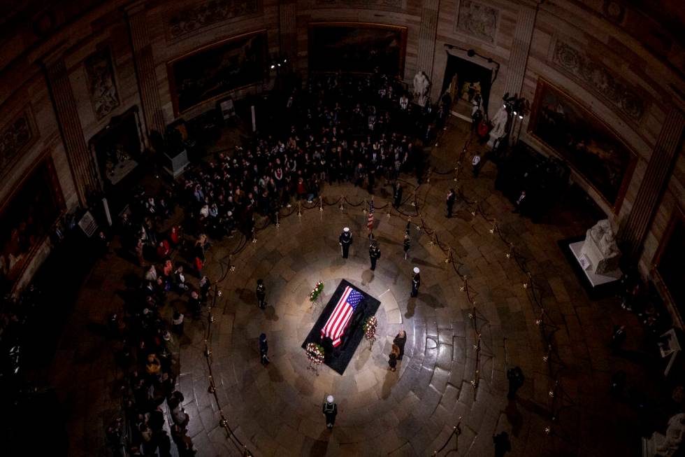 President-elect Donald Trump and Melania Trump pause at the flag-draped casket of former Presid ...