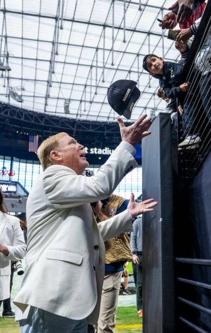 Raiders owner Mark Davis chats catches a hat to sign for a fan in the tunnel during warm ups be ...