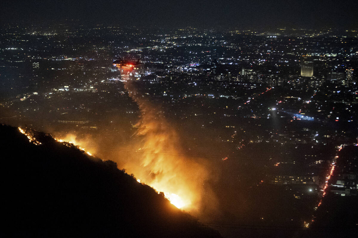 Water is dropped by helicopter on the burning Sunset Fire in the Hollywood Hills section of Los ...