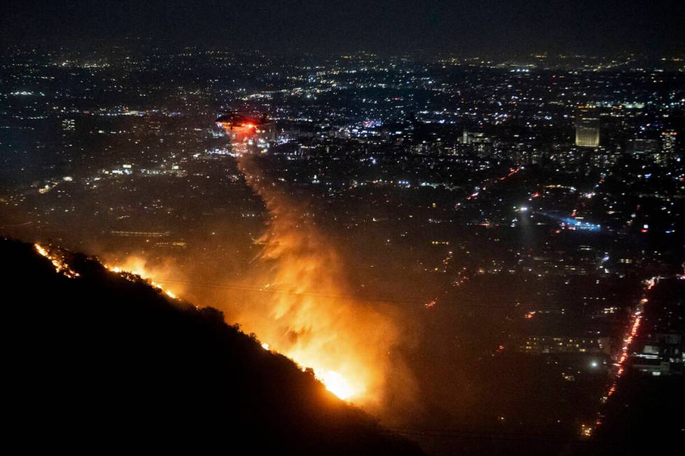 Water is dropped by helicopter on the burning Sunset Fire in the Hollywood Hills section of Los ...