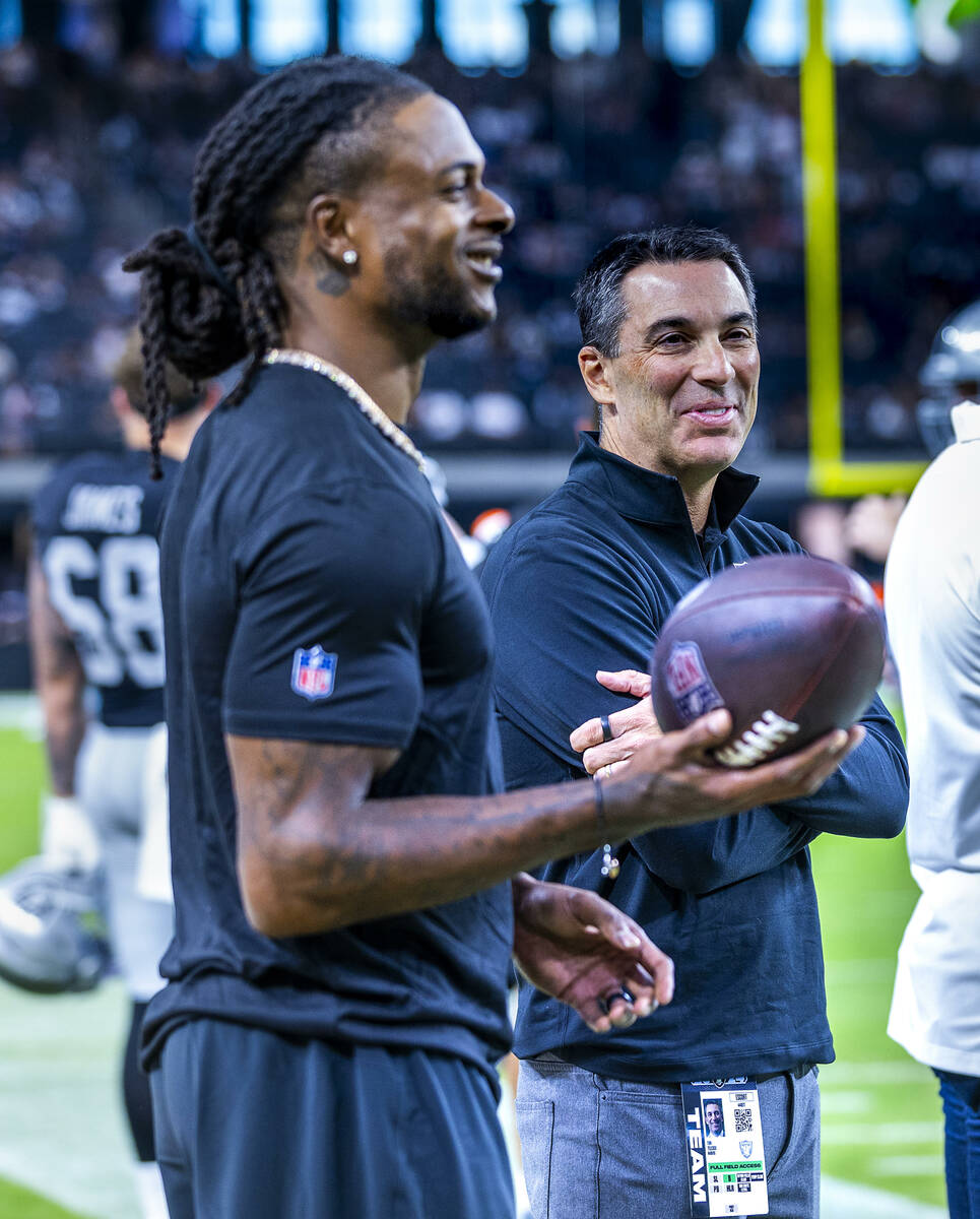 Raiders General Manager Tom Telesco stands on the sidelines with wide receiver Davante Adams (1 ...