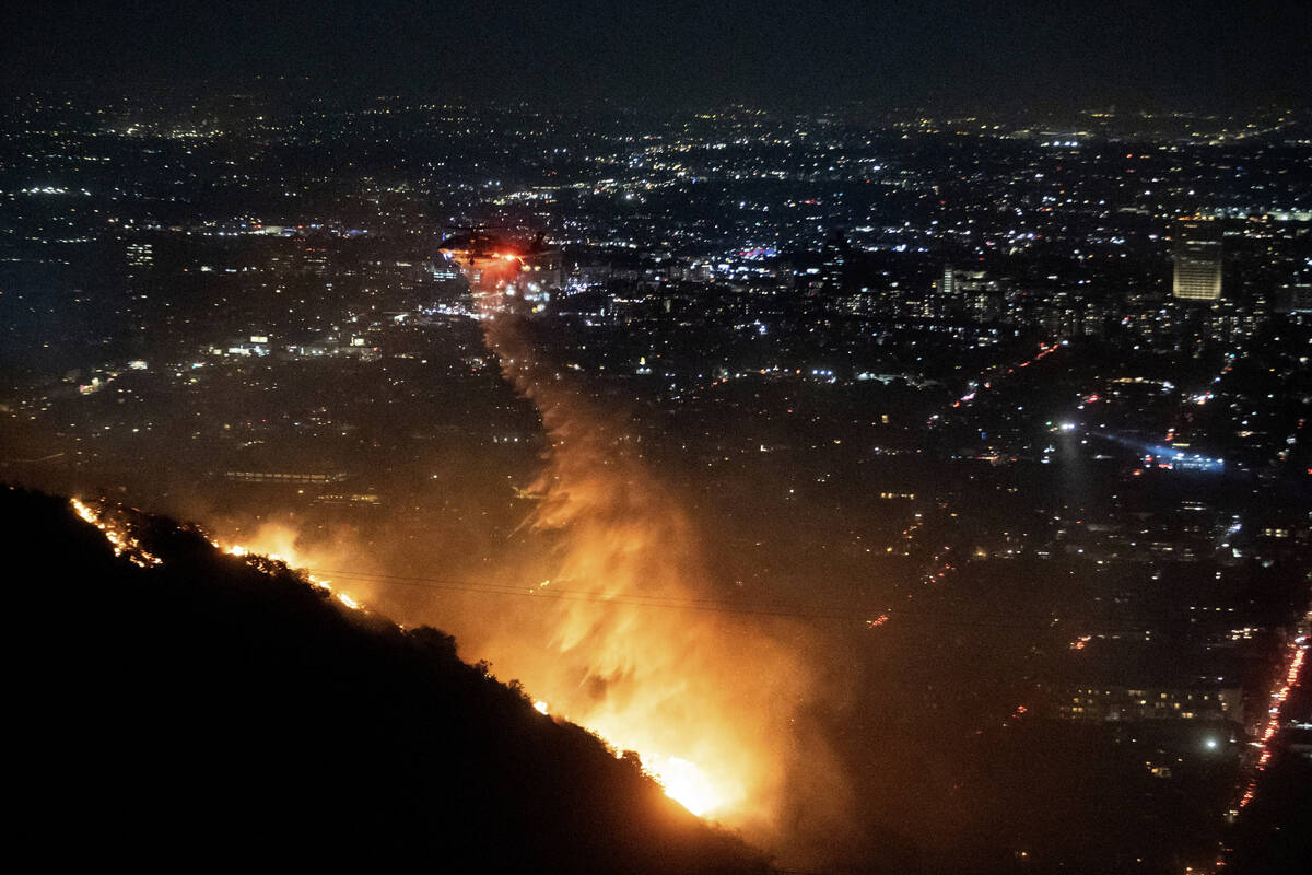 Water is dropped by helicopter on the burning Sunset Fire in the Hollywood Hills section of Los ...