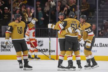 Golden Knights right wing Mark Stone (61) celebrates his goal with Golden Knights center Jack E ...