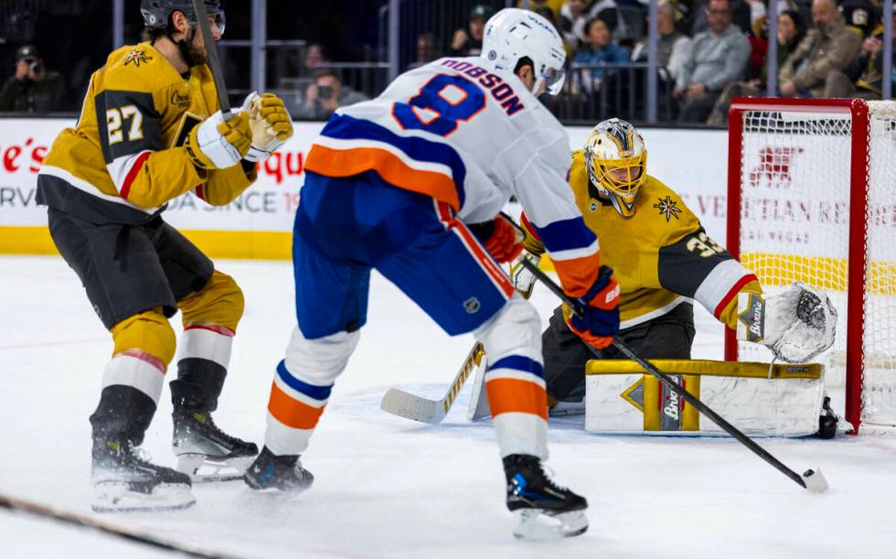 Golden Knights goaltender Adin Hill (33) defends the net as New York Islanders defenseman Noah ...