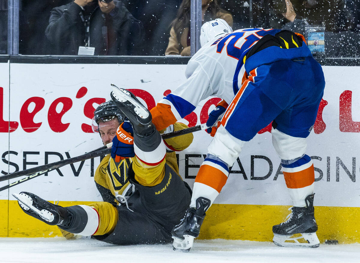 Golden Knights center Jack Eichel (9) is taken down to the ice by New York Islanders center Bro ...