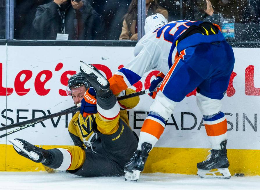 Golden Knights center Jack Eichel (9) is taken down to the ice by New York Islanders center Bro ...