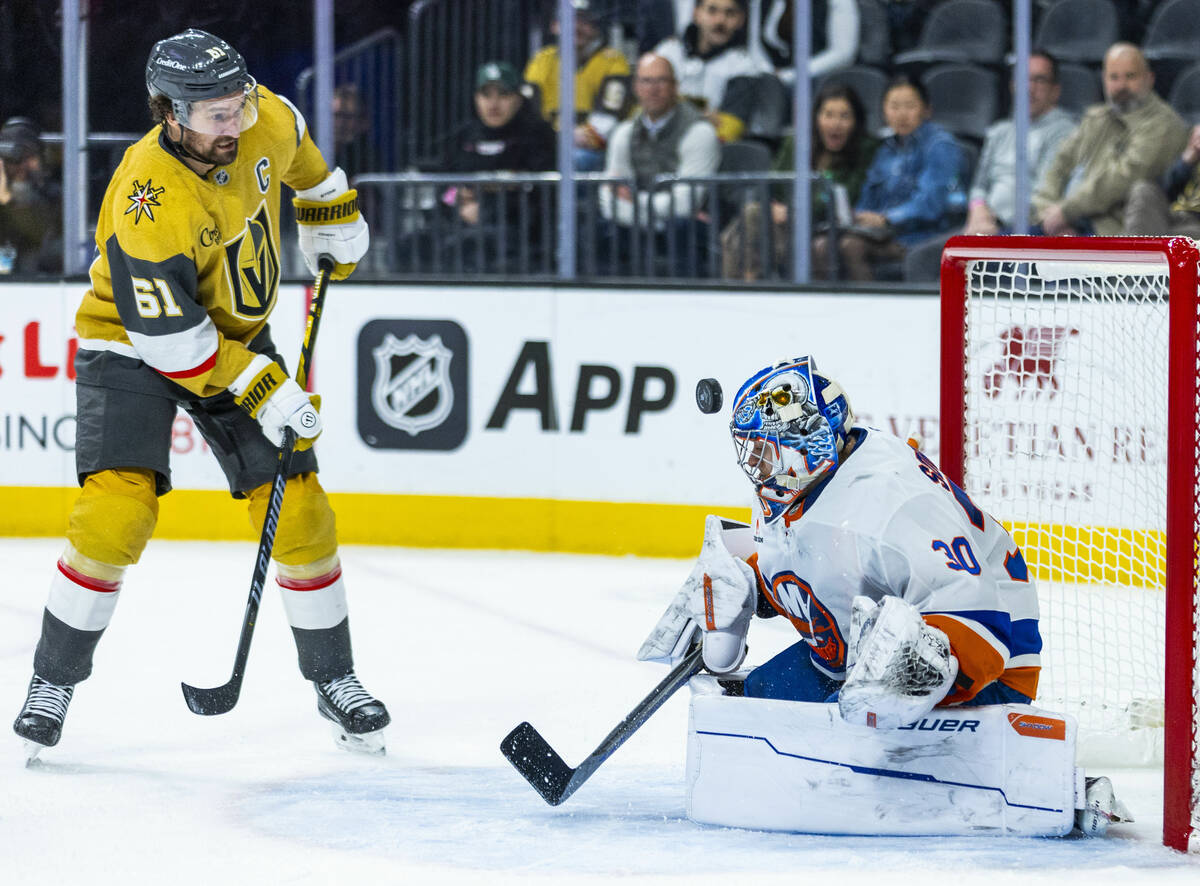 Golden Knights right wing Mark Stone (61) hits a puck off the helmet of New York Islanders goal ...