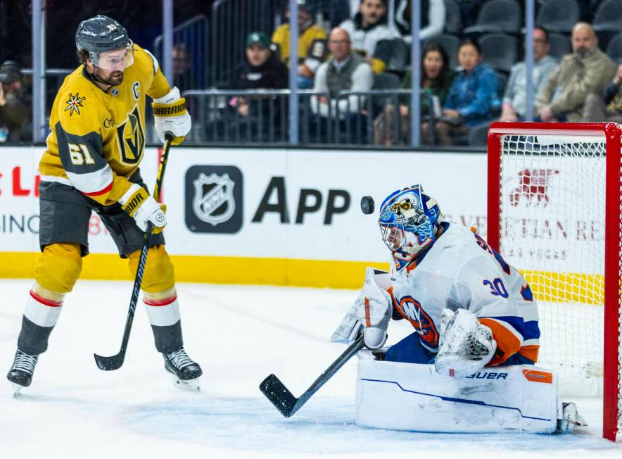 Golden Knights right wing Mark Stone (61) hits a puck off the helmet of New York Islanders goal ...