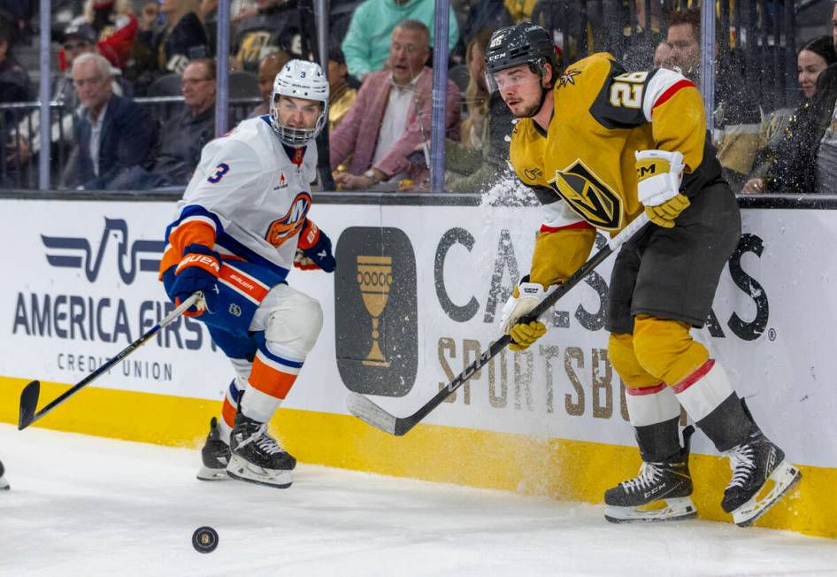 Golden Knights right wing Alexander Holtz (26) and New York Islanders defenseman Adam Pelech (3 ...